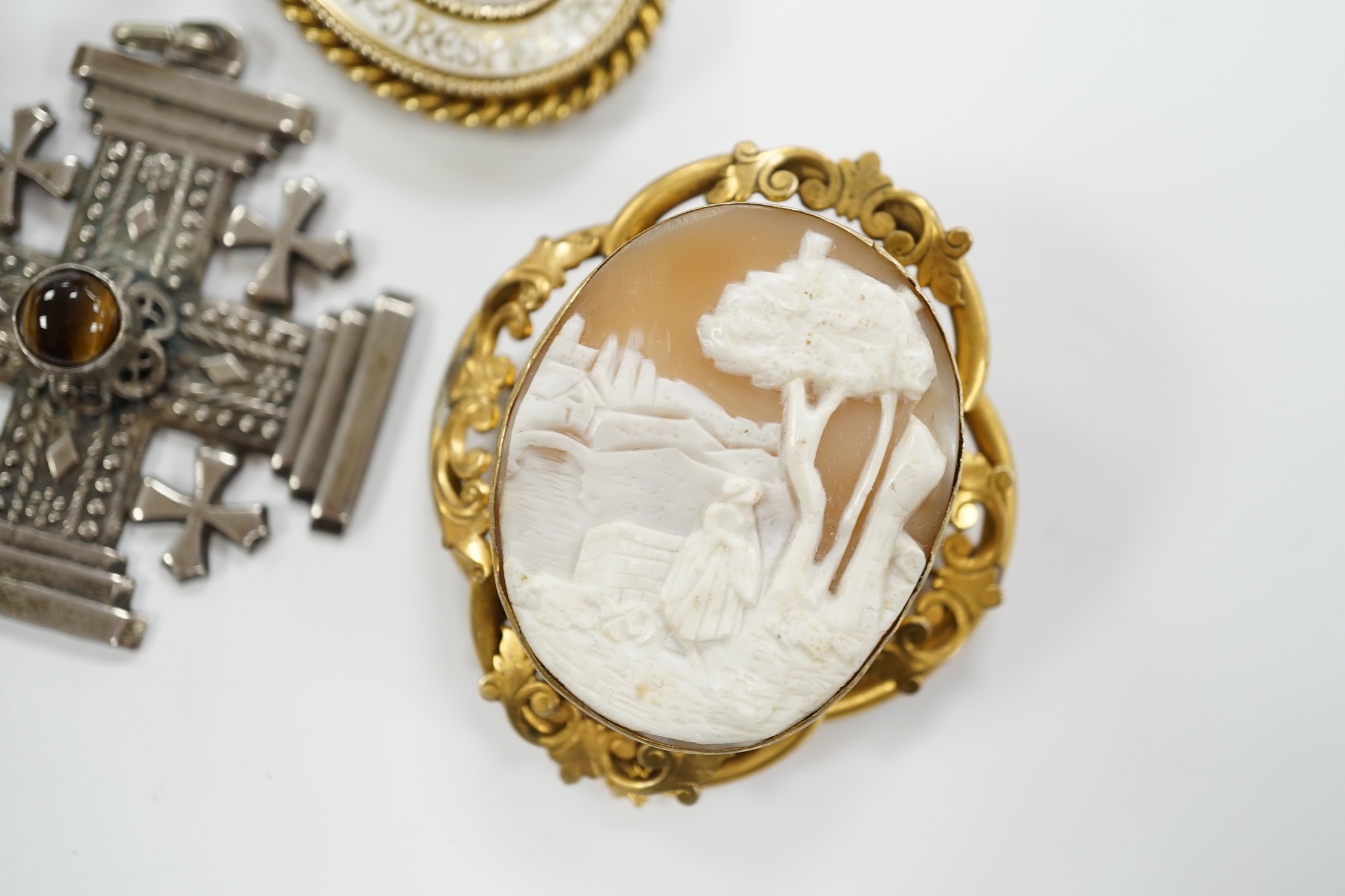 Sundry jewellery including a Victorian silver oval 'buckle' locket, overall 61mm, on a white metal belcher link chain, a continental 950 white metal and banded agate cabochon set cross pendant, a 1930's silver gilt and e